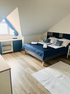 a bedroom with a bed with blue sheets and a window at Bálics Vendégház in Pécs