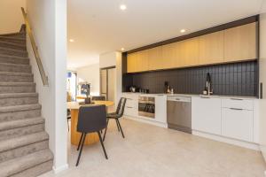 een keuken en eetkamer met een tafel en een trap bij Luxury CBD 2Bed2Bath With Parking Near Parks in Christchurch