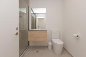 een badkamer met toilet, wastafel en douche bij Luxury CBD 2Bed2Bath With Parking Near Parks in Christchurch +15 foto's