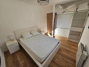 a small bedroom with a bed and a refrigerator at appartement le blanco neige in Puyvalador