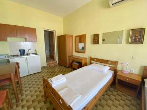 a bedroom with a large bed and a kitchen at Studio Apartment Sea View with Balcony in Diafani