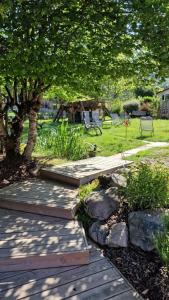 a wooden path in a park with a tree and a playground at Le Chalet de la Répandise - Gîte Vosges 9 pers, Spa privé & Piscine - Proche Gérardmer in Laveline-du-Houx
