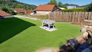 a fake lawn with a ping pong table on it at Le Chalet de la Répandise - Gîte Vosges 9 pers, Spa privé & Piscine - Proche Gérardmer in Laveline-du-Houx