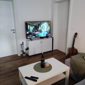 プトゥイにあるElegant City Escape Old Town Ptuj Apartmentのリビングルーム(テレビ、白いテーブル付)