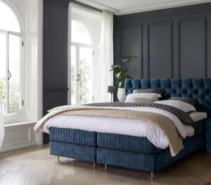a blue bed in a room with windows at Haus 1 in Niederdorla