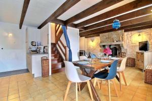 a kitchen and dining room with a wooden table and chairs at Gîtes du Cosquer in Malguénac