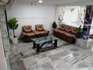a living room with two couches and a table at Stay Reliable in Udaipur
