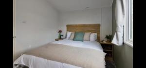 a bedroom with a white bed with a wooden headboard at Morsh Luxury Caravan Getaway in Colchester