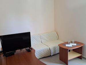 a living room with a tv and a couch and a table at Guest House Paskal in Sunny Beach