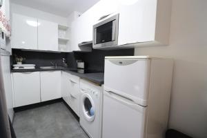 eine weiße Küche mit Waschmaschine und Trockner. in der Unterkunft Appartement Belle étoile - Cure, ski & spa in Brides-les-Bains
