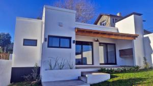 a white house with some stairs in front of it at Cabaña Matorras 480 in Tandil