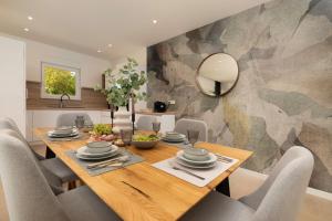 a dining room with a wooden table and chairs at Villa Hidden with heated pool in Dobrinj