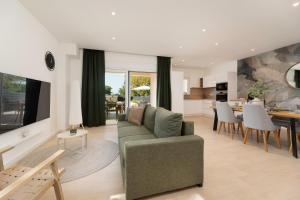 a living room with a couch and a dining room at Villa Hidden with heated pool in Dobrinj