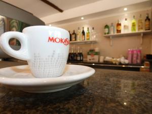 a coffee cup sitting on a plate on a counter at Cardiff Hotel in Marina di Camerota +22 photos