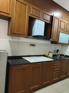a kitchen with wooden cabinets and a sink and a counter at Dcarlton seaview apartment in Masai