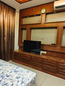a bedroom with a bed and a tv on a wooden wall at Dcarlton seaview apartment in Masai