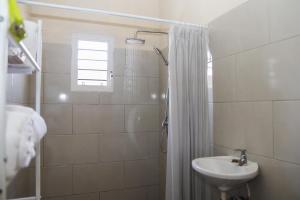 ein weißes Badezimmer mit Waschbecken und Dusche in der Unterkunft 4 Bedroom 3 Bathroom Outdoor Terrace with Amazing View in Willemstad + 9 Fotos