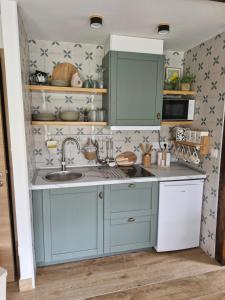 a kitchen with blue cabinets and a sink at "La casuca de Finu" #2# Santillana del Mar in Santillana del Mar