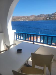a table and chairs on a balcony with the ocean at Romantza δωμάτιο 7 in Mérikhas