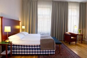 Hotel Bishops Arms Köping في كوبينغ: غرفه فندقيه بسرير وكرسي