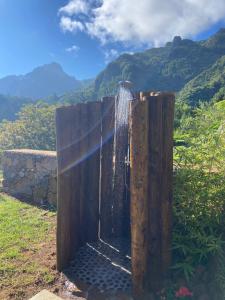 a wooden fence with a shower in front of a mountain at Casa Kalm - Private house with jacuzzi and mountain view in Senhora do Rosário