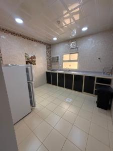 a large kitchen with a refrigerator and a sink at قمة الفخامة للشقق المخدومة in Al Hofuf