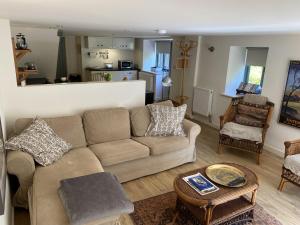 a living room with a couch and a table at Little Llanvolda in Saint Maughans