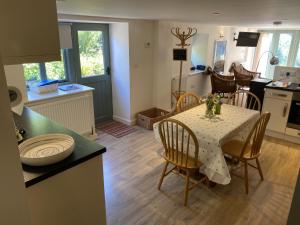 a kitchen and dining room with a table and chairs at Little Llanvolda in Saint Maughans +3 photos