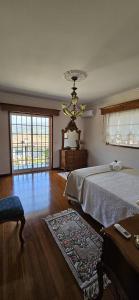 a bedroom with a bed and a chandelier at Casa das Boucinhas in São Sebastião de Penha Longa