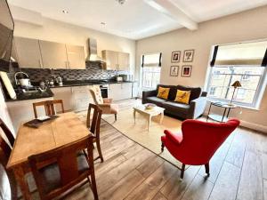 贝克韦尔Pass the Keys Old Beams Central Bakewell Stylish Duplex for 5的客厅配有桌子和红色椅子