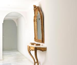 an ornate mirror on a console table in a room at Hotel Toboso Chaparil in Nerja