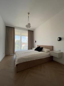 Un dormitorio con una cama grande y una ventana grande. en Apartament HYGGE, en Busko-Zdrój