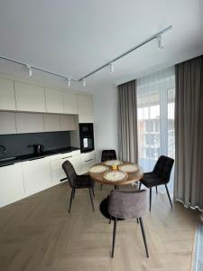 Una sala de estar con mesa y sillas y una cocina. en Apartament HYGGE, en Busko-Zdrój