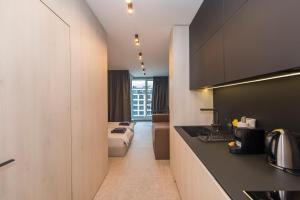eine Küche und ein Wohnzimmer mit einem Sofa in einem Zimmer in der Unterkunft Eleve Residences - Obsidian Studios in Sofia