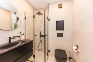 ein Badezimmer mit Dusche und Waschbecken in der Unterkunft Eleve Residences - Obsidian Studios in Sofia + 46 Fotos