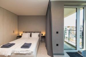 ein Schlafzimmer mit einem Bett und einem großen Fenster in der Unterkunft Eleve Residences - Obsidian Studios in Sofia