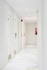 an empty hallway with white walls and white floors at Hotel Toboso Chaparil in Nerja