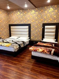 シュリーナガルにあるNew Damir palaceの壁付きのベッドルーム1室(ベッド2台付)