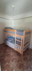 two bunk beds in a room with a wooden floor at Hospedaje Dase in Oxapampa