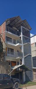 a building with a car parked in front of it at Hospedaje Dase in Oxapampa
