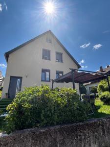 a white house with the sun in the sky at Ruhige Ferienwohnung im Schwarzwald in Schramberg