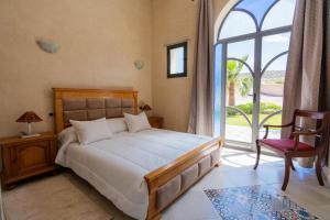 a bedroom with a bed and a large window at Villa Sultana by Living Essaouira in Essaouira