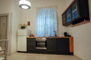 a kitchen with a white refrigerator and a black cabinet at Tinel Centrale in Imotski