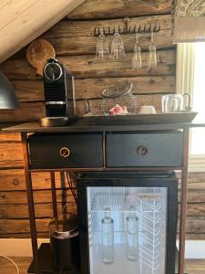 a wooden wall with a black dresser and a counter at Segelsund Boutique Gjestehus in Holvik +26 photos
