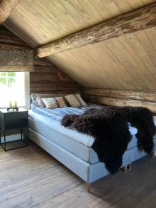 a bed in a room with a wooden ceiling at Segelsund Boutique Gjestehus in Holvik