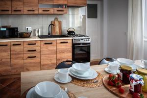 a kitchen with a table with white dishes on it at U Ludwiki in Chmielno +7 photos
