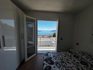 ArizzanoにあるModerno appartamento vista sul lago Maggioreのベッドルーム1室(ベッド1台付)、景色を望むバルコニーが備わります。