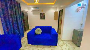 a living room with a blue couch and curtains at TemiHOUSE40 in Ibadan +1 photo