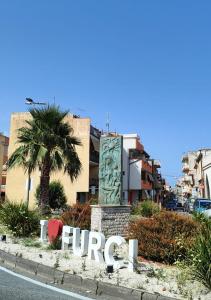 a sign for a hotel on a street with a palm tree at Casa Vacanze A Due Passi Dal Mare in Furci Siculo +1 photo