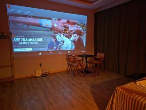 a projection screen in a room with a table and chairs at 028 Projector Palazio Vintage House Netflix Wifi in Johor Bahru
